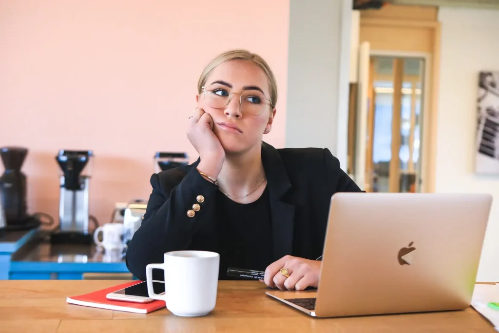 Imagem de mulher pensativa em frente ao computador pensando em contabilidade para psicólogos
